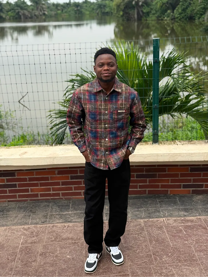 Olumide standing by a lake